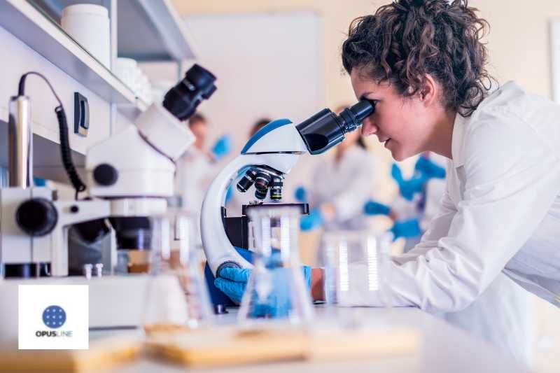 une jeune fille dans un laboratoire scolaire observant avec un microscope. Établis scolaires Instituts techniques